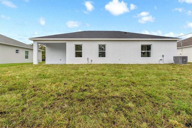 rear view of property with cooling unit and a lawn