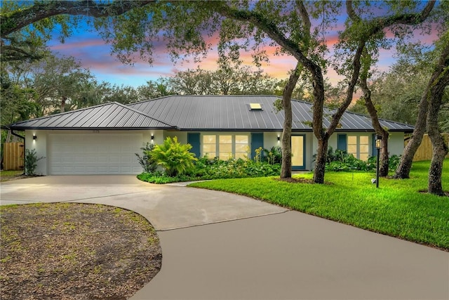 single story home with a garage and a yard