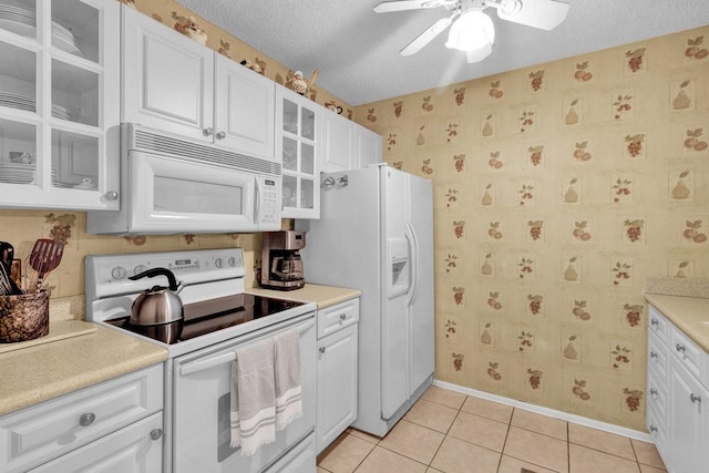 kitchen with a ceiling fan, white cabinetry, light tile patterned flooring, and white appliances