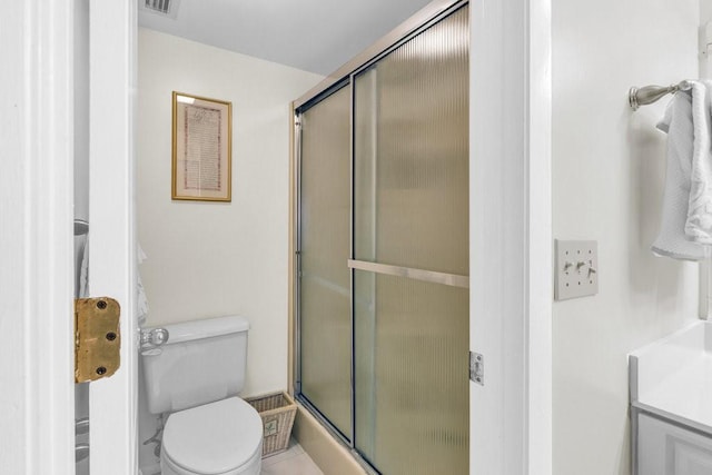 bathroom with toilet and a shower with door