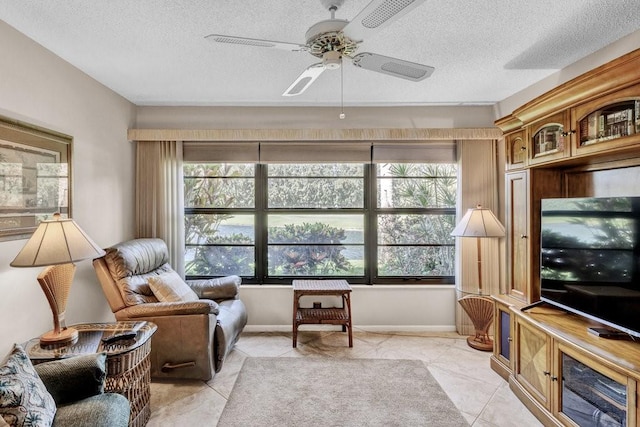 interior space featuring a wealth of natural light, a textured ceiling, and a ceiling fan