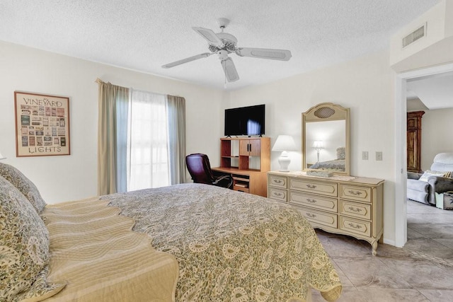 bedroom with a textured ceiling, ceiling fan, and visible vents