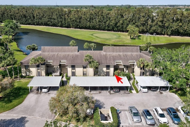 birds eye view of property with a water view, a wooded view, and view of golf course