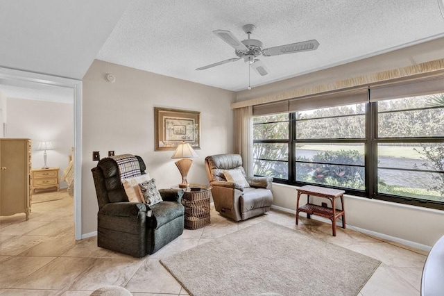 sitting room with a textured ceiling, ceiling fan, and baseboards