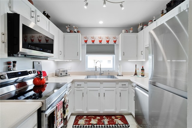 kitchen with white cabinets, light tile patterned flooring, sink, and appliances with stainless steel finishes