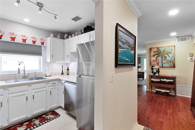 kitchen with white cabinetry, sink, stainless steel appliances, and light wood-type flooring