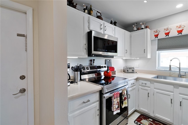 kitchen with white cabinets, light tile patterned flooring, sink, and appliances with stainless steel finishes