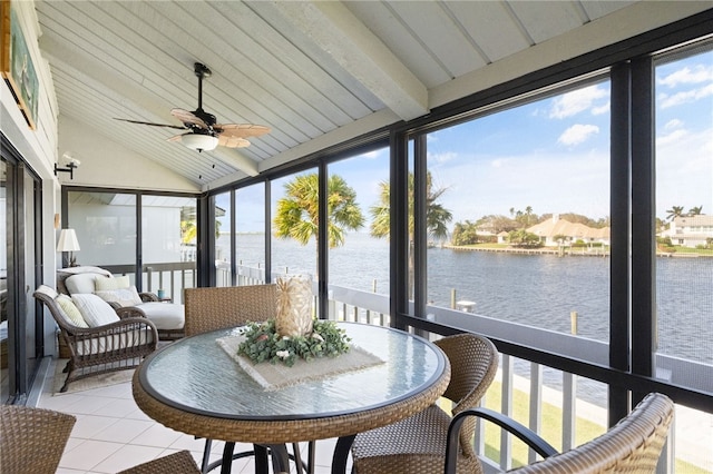 sunroom / solarium featuring lofted ceiling with beams, a water view, a wealth of natural light, and ceiling fan