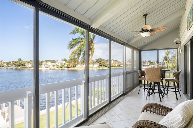 sunroom with vaulted ceiling with beams, a water view, and ceiling fan