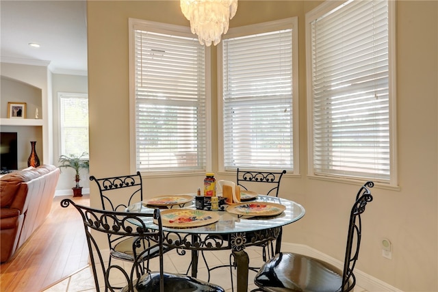 dining room with a notable chandelier, light hardwood / wood-style floors, and crown molding