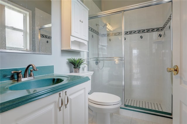 bathroom featuring toilet, vanity, tile patterned flooring, and walk in shower