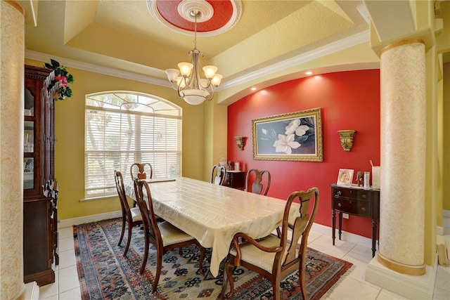 tiled dining space featuring a chandelier, a tray ceiling, ornate columns, and crown molding