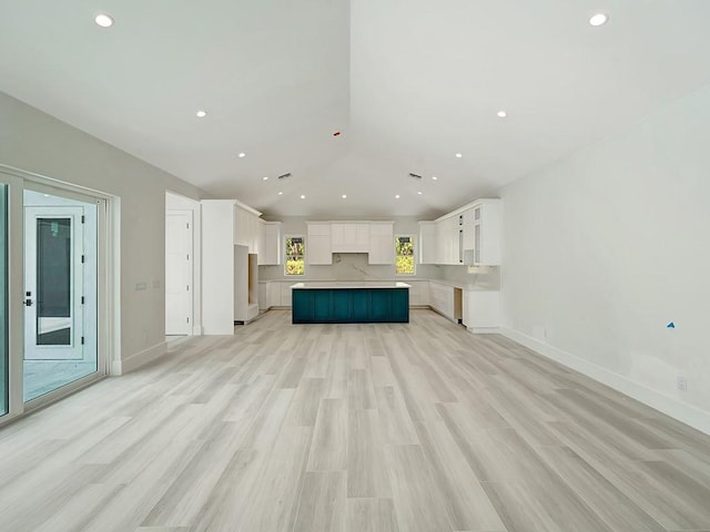 985 Clipper Rd, Vero Beach, FL 32963 - unfurnished living room with lofted ceiling, recessed lighting, and light wood-style flooring