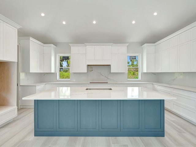 985 Clipper Rd, Vero Beach, FL 32963 - kitchen featuring plenty of natural light, a center island, backsplash, white cabinetry, and recessed lighting