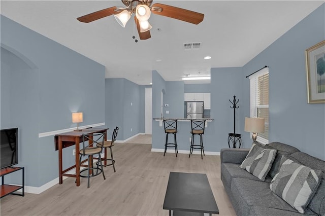 living room with light wood-type flooring and ceiling fan