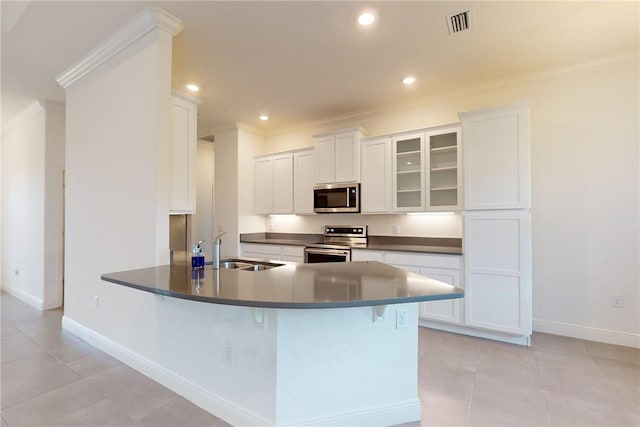 2545 Saint Lucia Cir, Vero Beach, FL 32967 - kitchen with appliances with stainless steel finishes, ornamental molding, a sink, baseboards, and white cabinets