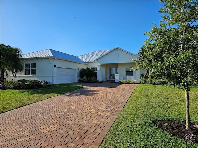 2545 Saint Lucia Cir, Vero Beach, FL 32967 - ranch-style house featuring decorative driveway, a front lawn, an attached garage, and metal roof