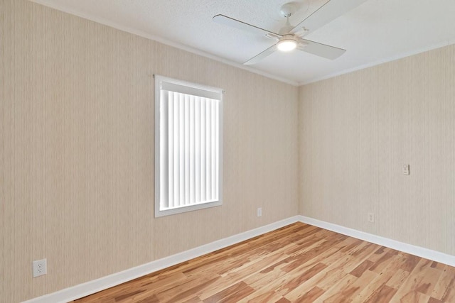 empty room featuring ceiling fan, crown molding, and hardwood / wood-style flooring