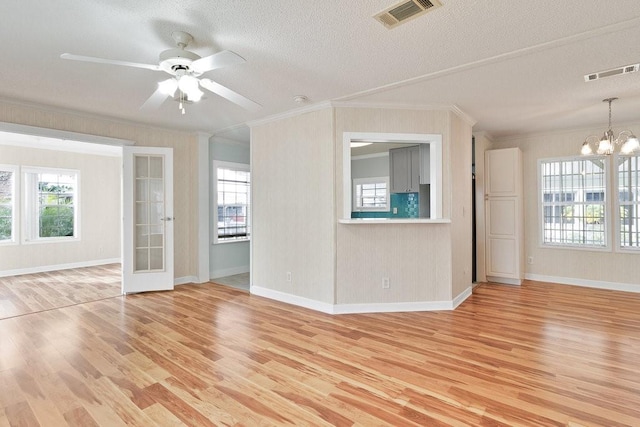 unfurnished living room with a textured ceiling, ornamental molding, and light hardwood / wood-style floors