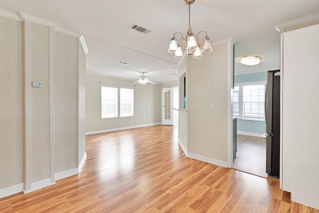 spare room featuring ceiling fan with notable chandelier, crown molding, and light hardwood / wood-style floors