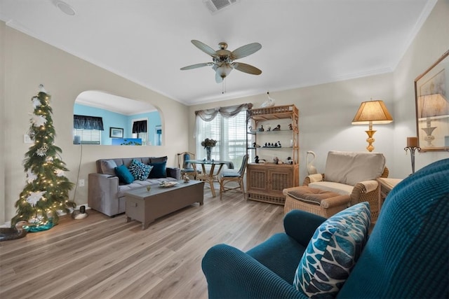 living room with ceiling fan, light wood-type flooring, and ornamental molding