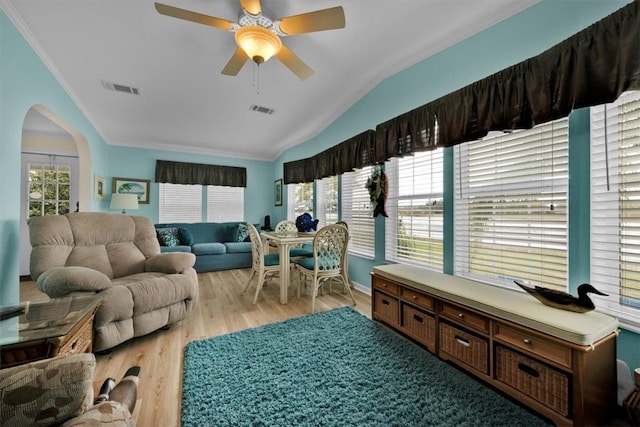 living room with ceiling fan, lofted ceiling, ornamental molding, and light hardwood / wood-style flooring