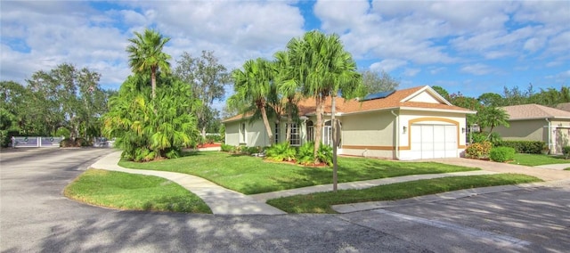 view of front of house featuring a garage, a front yard, and solar panels