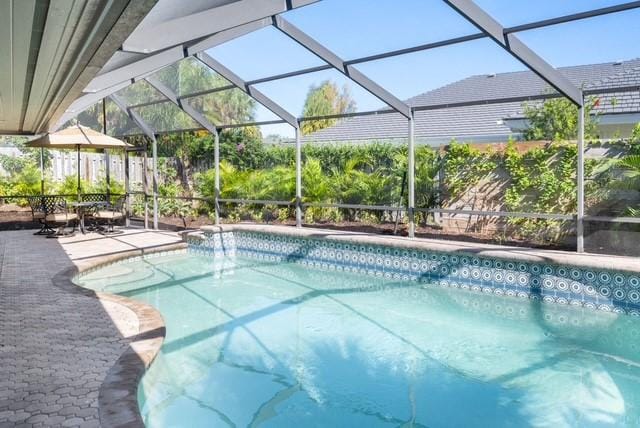 1786 Cypress Ln, Vero Beach, FL 32963 - outdoor pool with glass enclosure and a patio area