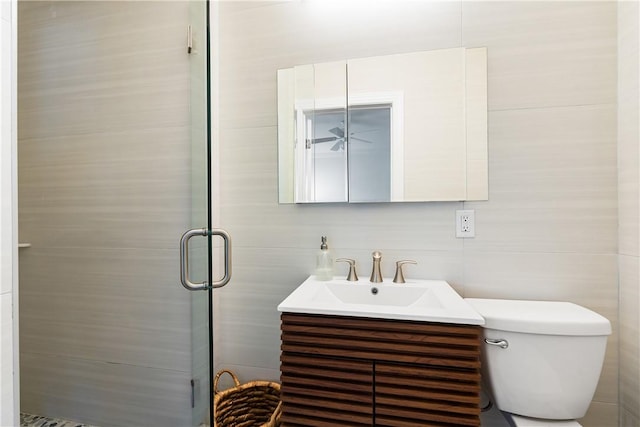 bathroom featuring vanity, a shower with door, and toilet