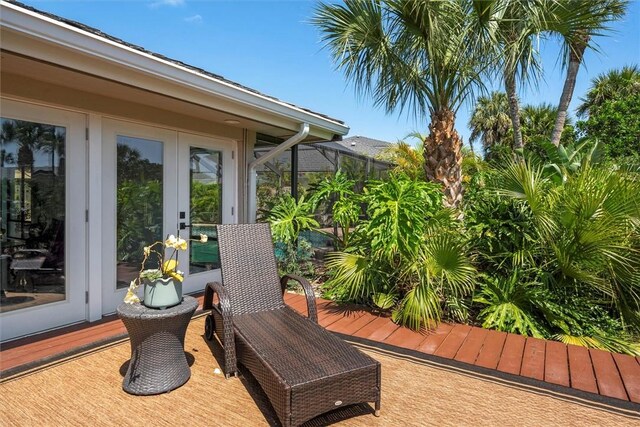 wooden terrace featuring french doors and glass enclosure