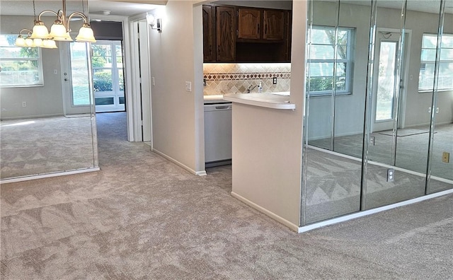 kitchen with light colored carpet, light countertops, decorative backsplash, dark brown cabinetry, and dishwasher