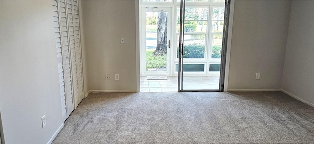 doorway to outside featuring carpet floors and baseboards