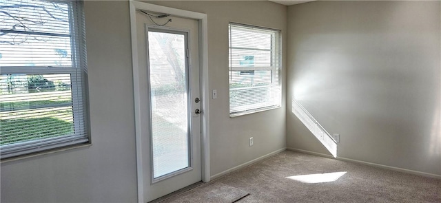 entryway with carpet floors, a healthy amount of sunlight, and baseboards