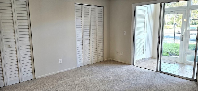 unfurnished bedroom with baseboards, access to outside, and light colored carpet