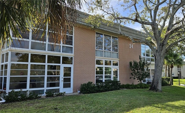 view of home's exterior featuring a lawn and brick siding