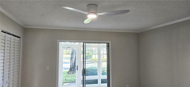 doorway featuring ceiling fan, ornamental molding, and a textured ceiling