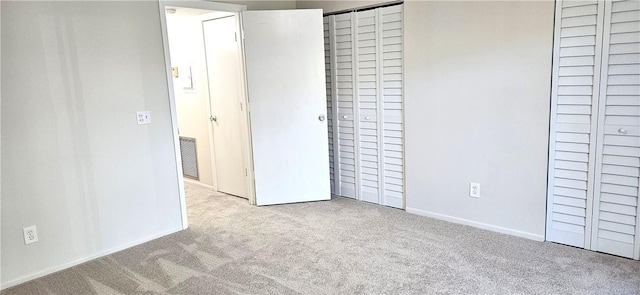 unfurnished bedroom featuring baseboards, visible vents, and light colored carpet