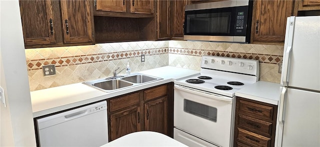 kitchen with tasteful backsplash, white appliances, light countertops, and a sink