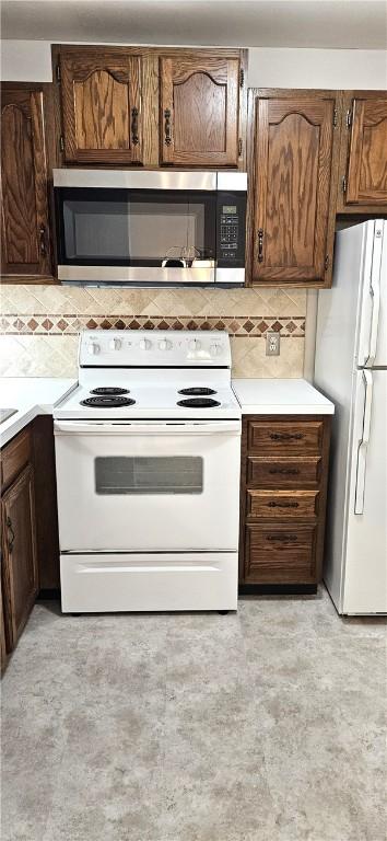 kitchen with white appliances, light countertops, and decorative backsplash