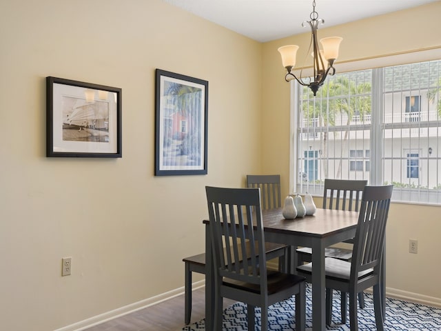 dining space with hardwood / wood-style floors and a chandelier