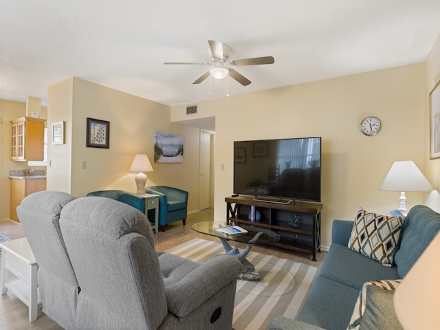 living room with ceiling fan and light wood-type flooring