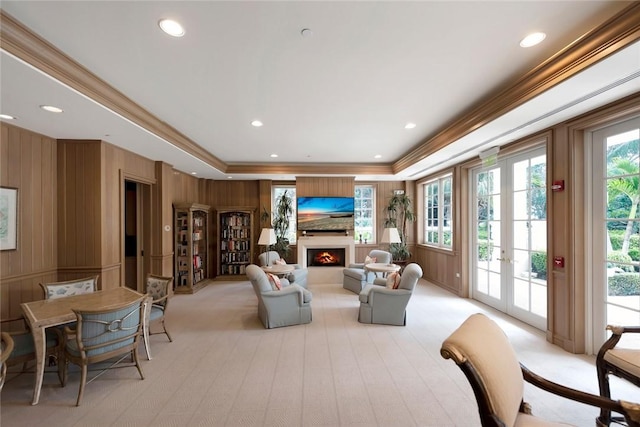 living room featuring a warm lit fireplace, ornamental molding, recessed lighting, and light colored carpet