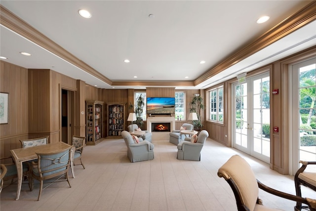 living room featuring wood walls, french doors, and crown molding