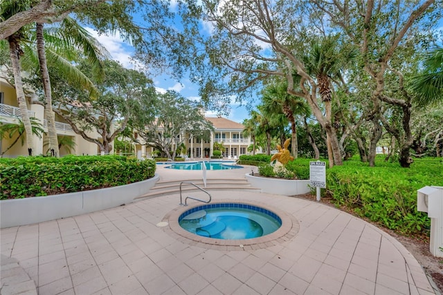 view of swimming pool with a hot tub and a patio