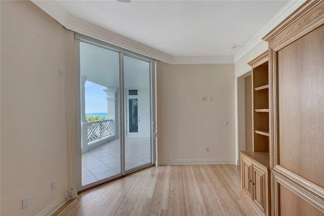 spare room with light wood-type flooring and crown molding