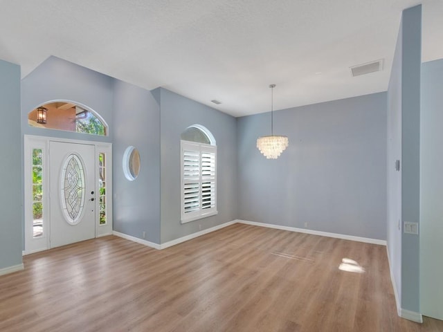 foyer entrance featuring an inviting chandelier and light wood-type flooring