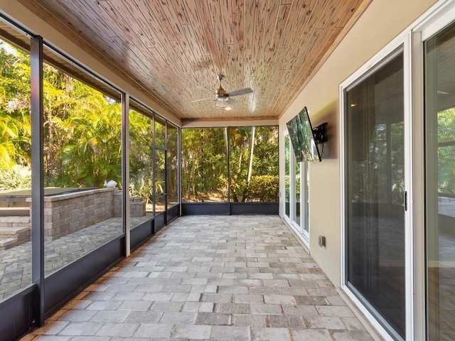 unfurnished sunroom featuring ceiling fan and wooden ceiling