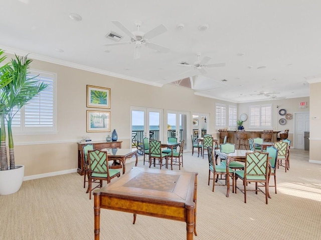 interior space with ceiling fan, ornamental molding, light carpet, and a wealth of natural light