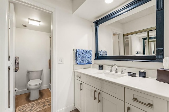 28 Plantation Dr Unit 204, Vero Beach, FL 32966 - bathroom with toilet, vanity, a shower stall, wood finished floors, and baseboards