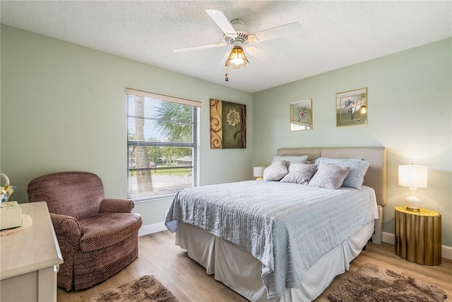 28 Plantation Dr Unit 204, Vero Beach, FL 32966 - bedroom with light wood-type flooring, baseboards, a ceiling fan, and a textured ceiling
